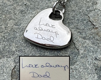 May include: Silver heart necklace with a handwritten inscription that reads "Love always Dad".
