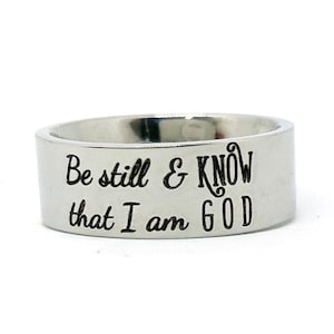 May include: A silver ring with the inscription "Be still & KNOW that I am GOD" engraved on the band.