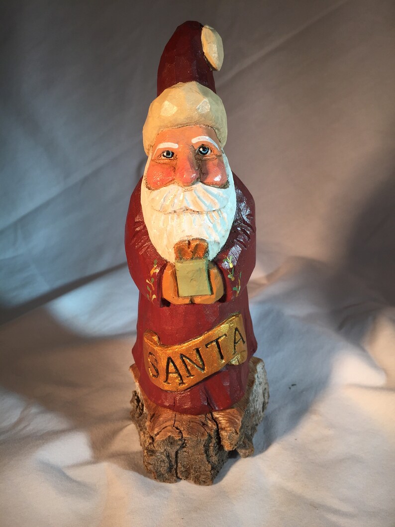 Santa with a gift and \u201cSanta\u201d banner