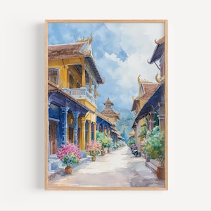 May include: Watercolor painting of a street scene in a Southeast Asian city. The buildings are yellow with blue trim and have ornate roofs. The street is lined with trees and flowers.