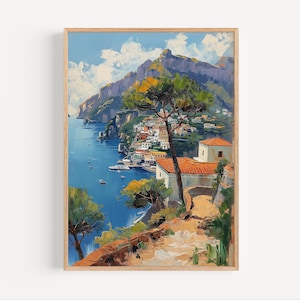 May include: A framed art print of a coastal Italian town. The painting shows a vibrant scene with a blue sea, white buildings with orange roofs, and green trees. A mountain range is in the background, under a blue sky with clouds.