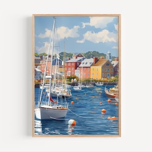 May include: A framed print of a harbor scene with sailboats and colorful buildings. The artwork depicts a sunny day with a blue sky and fluffy white clouds. Orange buoys float in the water, adding a pop of color to the scene.