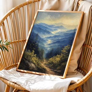 May include: A framed painting of a mountain landscape with a winding path leading through the trees. The mountains are painted in shades of blue and green, with a hazy mist in the distance. The painting is set against a backdrop of a light brown wicker chair.