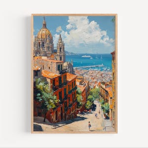 May include: A framed art print of a cityscape with a cathedral and buildings with orange rooftops. The painting depicts a coastal town with a blue sea, white clouds, and a harbor with boats. The artwork has a warm color palette and a textured, painterly style.