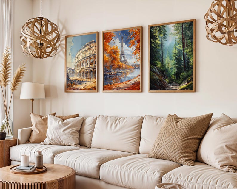 May include: Three framed art prints depicting iconic landmarks and a forest scene. The first print shows the Colosseum in Rome, the second the Eiffel Tower in Paris, and the third a lush forest path. The prints are displayed above a cream-colored sofa.