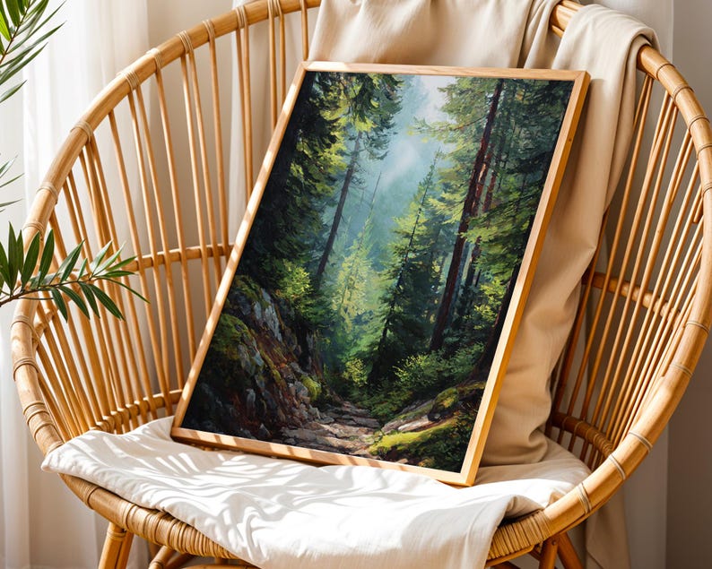 May include: A framed landscape art print depicting a forest scene with tall trees and a path. The artwork features a palette of greens, browns, and blues, with sunlight filtering through the trees. The frame is made of light-colored wood.