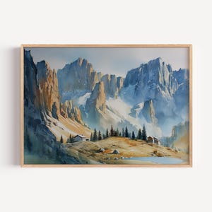 Könnte beinhalten: Aquarellmalerei einer Berglandschaft mit schneebedeckten Gipfeln und einem kleinen See. Das Kunstwerk in einem Holzrahmen zeigt eine ruhige Szene mit Hütten am Fuße der Berge.