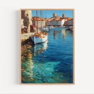 May include: A framed painting depicts a harbor scene with boats docked in turquoise water. Buildings with orange rooftops line the shore under a clear blue sky. The artwork has a textured, impressionistic style, with visible brushstrokes.