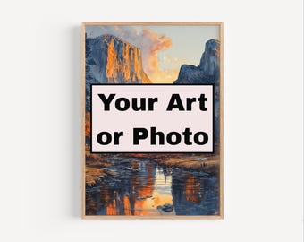 May include: A framed landscape art print depicting a mountain range and river at sunset. The artwork has a light wood frame and includes the text "Your Art or Photo" in a black font on a pink background.