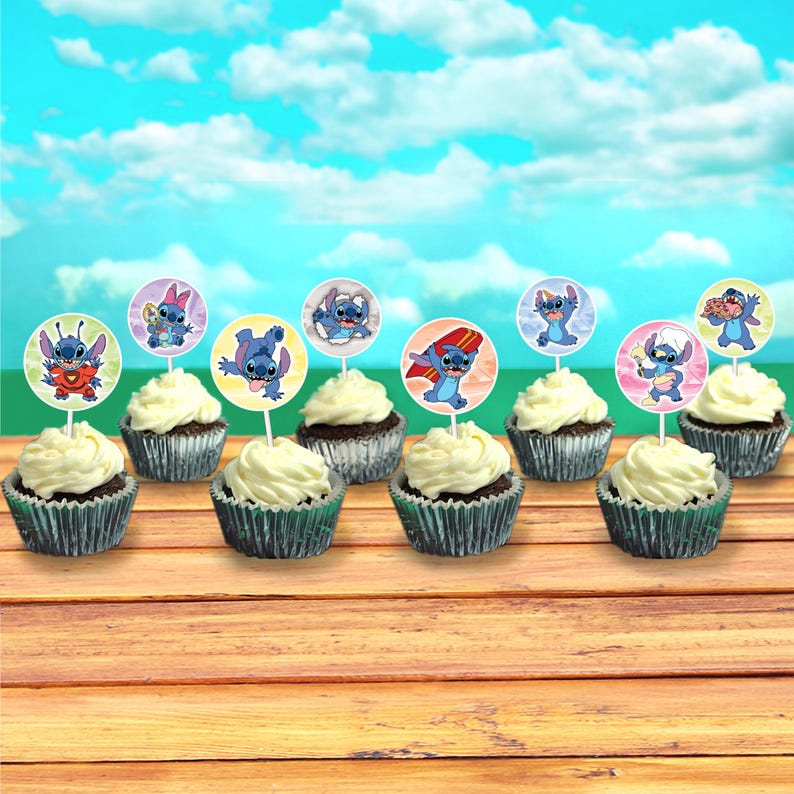 May include: Cupcakes with white frosting and decorative toppers featuring the character Stitch from Lilo & Stitch. The cupcakes sit on a wooden surface against a backdrop of a blue sky with clouds. The toppers have different images of Stitch.