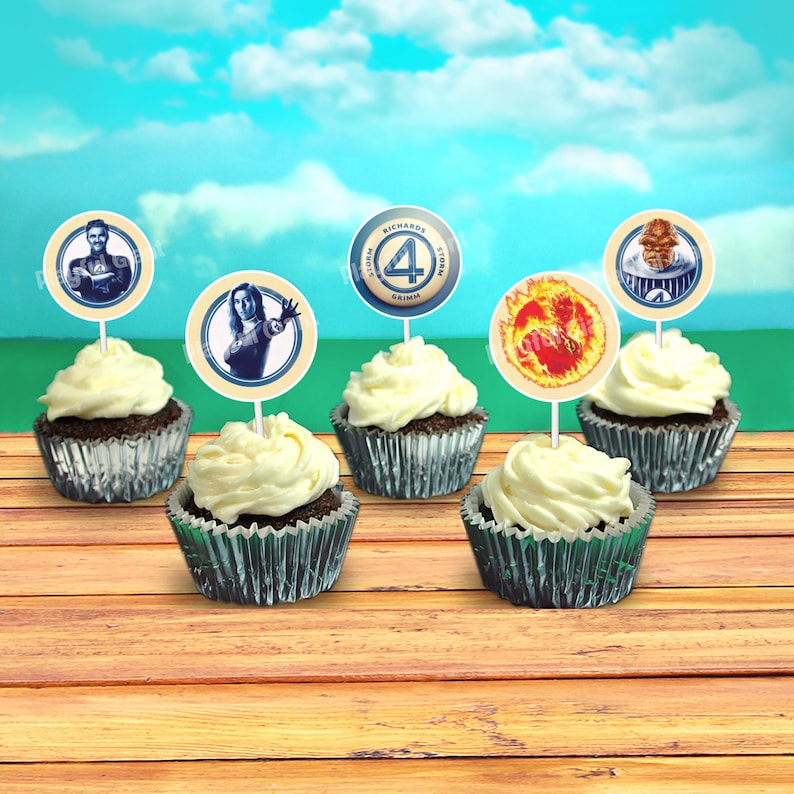 Op de afbeelding: Zes cupcakes versierd met Fantastic Four-thema toppers. De toppers tonen de personages Mr. Fantastic, Invisible Woman, Human Torch en The Thing. De cupcakes zijn bedekt met witte frosting en zijn gerangschikt op een houten oppervlak.