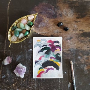 May include: A watercolor painting on paper with a white background and colorful abstract shapes in shades of pink, purple, yellow, green, and black.