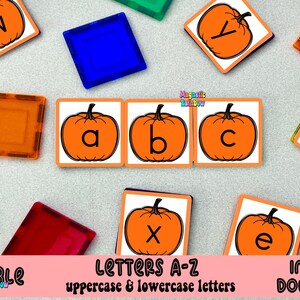 Peut inclure: Impression éducative avec des cartes de lettres sur le thème de la citrouille orange avec des lettres majuscules et minuscules. Les lettres sont affichées sur des carrés blancs avec une bordure orange. Des tuiles magnétiques colorées entourent les cartes. Le texte "Letters A-Z" est visible.