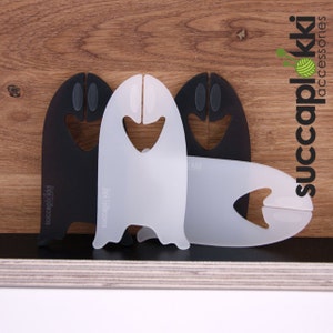 Peut inclure: Trois supports de bol à laine en plastique en forme de fantômes. Deux sont noirs et un est blanc. Les supports ont un petit trou en haut pour accrocher et un trou plus grand à l'avant pour tenir la laine.