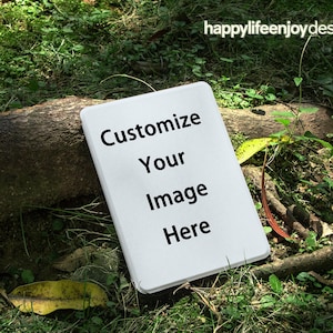May include: A white rectangular sign with rounded corners, featuring the text "Customize Your Image Here" in black. The sign is set against a backdrop of green grass, leaves, and a tree branch. The words "happylifeenjoydesign" are in the top right corner.