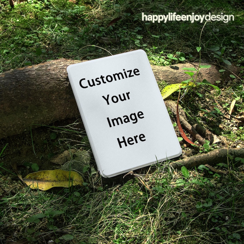Puede incluir: Un letrero rectangular blanco con esquinas redondeadas, con el texto "Customize Your Image Here" en negro. El letrero est&aacute; sobre un fondo de hierba verde, hojas y una rama de &aacute;rbol. Las palabras "happylifeenjoydesign" est&aacute;n en la esquina superior derecha.