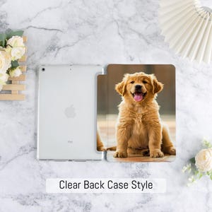 Może przedstawiać: Przezroczyste etui na iPada z przezroczystym tyłem i okładką przedstawiającą szczeniaka golden retrievera. Szczeniak ma radosny wyraz twarzy z wystawionym językiem. Tekst "Clear Back Case Style" znajduje się na dole.