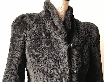 May include: A black faux fur jacket with a high collar and button closure. The jacket has a textured, curly fur design.