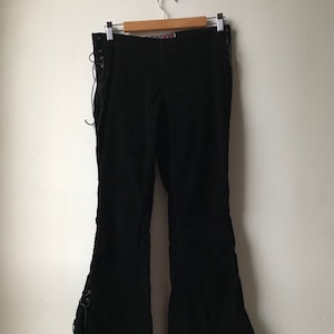 K&ouml;nnte beinhalten: Schwarze Cordhose mit Glockenbeinen und Schn&uuml;rdetails an den Seiten.