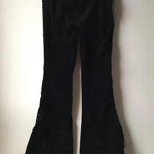 K&ouml;nnte beinhalten: Schwarze Samt-Hose mit Schn&uuml;rdetails an den Seiten und am Beinabschluss.