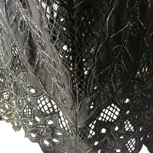 May include: Black lace fabric with a delicate floral pattern and a silver thread detail.