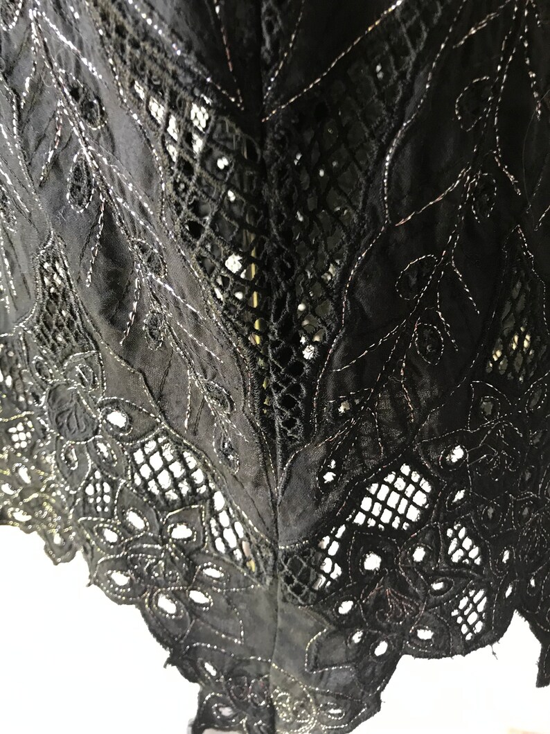 May include: Black lace fabric with a delicate floral pattern and a silver thread detail.