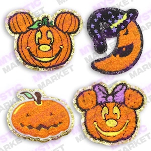May include: Four Halloween-themed felt patches featuring pumpkin faces. One patch is a pumpkin with Mickey Mouse ears, another is a pumpkin with Minnie Mouse ears, another is a pumpkin with a traditional jack-o'-lantern face, and the last is a crescent moon with a witch's hat.