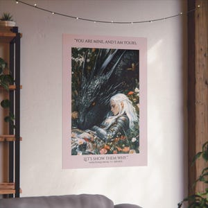 May include: A pink poster with a quote from the book "Throne of Glass" by Sarah J. Maas. The quote reads "You are mine, and I am yours. Let's show them why." The poster features a black dragon and a woman with white hair.