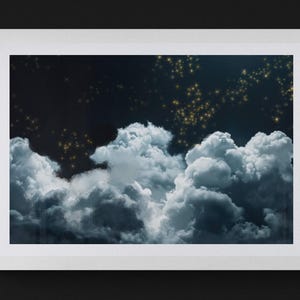 May include: A framed print featuring a night sky scene. The artwork depicts fluffy, white and gray clouds against a dark blue background. Golden stars are scattered across the upper portion of the image, creating a dreamy atmosphere.