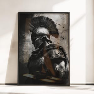 Puede incluir: Obra de arte enmarcada que presenta una ilustración en escala de grises de un soldado romano de perfil. El soldado lleva un casco detallado con una cresta alta y emplumada y una armadura. La obra de arte tiene un estilo texturizado y pictórico, con salpicaduras y sombreado.