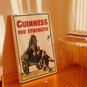 K&ouml;nnte beinhalten: Gerahmtes Vintage-Guinness-Werbeposter. Das Poster zeigt einen Pferdewagen mit einem Mann und dem Text "GUINNESS FOR STRENGTH" in Rot. Das Poster befindet sich in einem wei&szlig;en Rahmen mit gr&uuml;nem Rand.