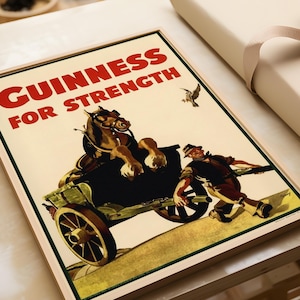 K&ouml;nnte beinhalten: Gerahmtes Vintage Guinness-Poster. Das Bild zeigt ein Pferd, das einen Wagen zieht, mit einem Mann, der ihn bergauf schiebt. Der Text "GUINNESS FOR STRENGTH" ist rot auf cremefarbenem Hintergrund. Ein Vogel fliegt in der oberen rechten Ecke.