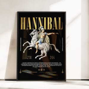 Puede incluir: Lámina artística enmarcada en negro con el nombre "HANNIBAL" en letras doradas. La obra representa a un guerrero a caballo, con los años 218 y 204 debajo. También incluye una cita.