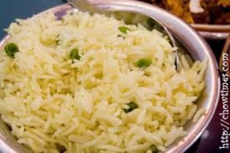 May include: A bowl of white rice with green peas, a common side dish in Indian cuisine.