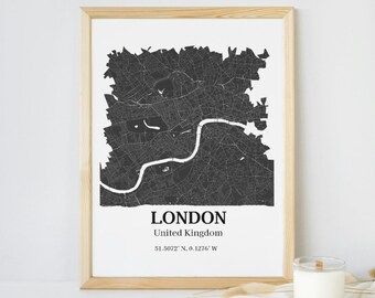 May include: A black and white map print of London, United Kingdom, in a light wood frame. The map shows the city's streets and landmarks. The text "LONDON" and "United Kingdom" are printed below the map, along with the coordinates "51.5072° N, 0.1276° W".