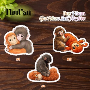 May include: Three monkey stickers with different poses. One sticker shows two monkeys hugging, another shows a monkey hugging a stuffed monkey, and the last shows a monkey sitting on a stuffed monkey. The stickers are on a wooden surface.