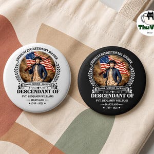 May include: Two circular badges, one white and one black, with an illustration of an American Revolutionary War soldier. Text includes "American Revolutionary Soldier," "Descendant of Pvt. Benjamin Williams," and "Honor - Service - Sacrifice."