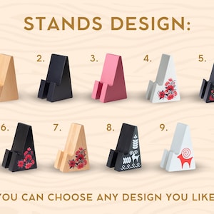 May include: A variety of wooden phone stands in different colors and designs. The stands are numbered and include options in natural wood, black, pink, white with floral patterns, and black with folk art designs. The text "STANDS DESIGN" and "YOU CAN CHOOSE ANY DESIGN YOU LIKE" are visible.