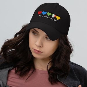 May include: Black baseball cap with the text "ONE DIRECTION" and five colorful hearts embroidered on the front.