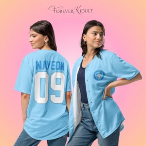 May include: Light blue baseball jersey with the name "NAYEON" and the number "09" on the back. The jersey has a button-up front and a circular patch with a skull design on the front. The text "FOREVER KIDULT" is at the top.