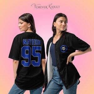 May include: Black baseball jersey with blue detailing. The jersey displays the name "NAYEON" and the number "95" in blue on the back. A blue and white circular logo is on the front. The brand name "FOREVER KIDULT" is at the top.
