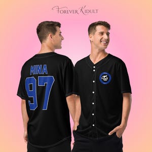 May include: Black baseball jersey with white buttons and a blue and white logo on the chest. The back of the jersey has the name "MINA" and the number "97" in blue. The text "FOREVER KIDULT" is at the top.
