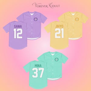 May include: Baseball jerseys in pastel colors: lavender, yellow, and mint green. Each jersey has a name and number on the back. The jerseys have a button-up front and a small logo on the chest. The text "Forever Kidult" is at the top.