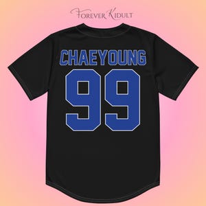 May include: Black baseball jersey featuring the name "CHAEYOUNG" in blue lettering and the number "99" in blue with a white outline. The jersey has a rounded hemline and short sleeves. The brand name "Forever Kidult" is at the top.