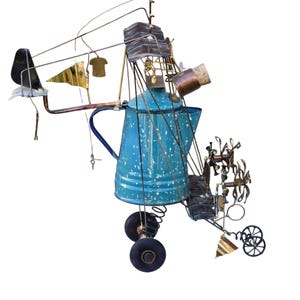 May include: A quirky metal sculpture in the shape of an aircraft, incorporating a blue speckled enamel coffee pot. The artwork is composed of various metal parts, wheels, and decorative details, resulting in a distinctive and artistic creation.