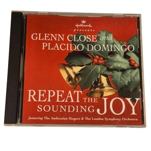 May include: A CD case with a red cover featuring the text "GLENN CLOSE and PLACIDO DOMINGO" and "REPEAT THE SOUNDING JOY". The cover includes images of gold bells, holly, and red berries.