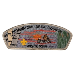 Puede incluir: Un parche bordado de color beige y gris con el texto "Potawatomi Area Council Wisconsin". El parche presenta una puesta de sol sobre un lago con una canoa y una persona remando. Hay abedules a la izquierda y juncos a la derecha.