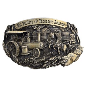 Può includere: Fibbia per cintura in stile vintage con una scena in rilievo dettagliata. La fibbia presenta una locomotiva a vapore, una carrozza trainata da cavalli e il testo "Old Settlers and Threshers Reunion" e "Mt. Pleasant Iowa". La fibbia ha una finitura bronzo.