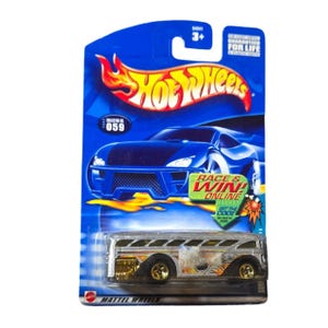 May include: A silver Hot Wheels toy bus with gold wheels and flame decals, packaged on a blue card. The card features the Hot Wheels logo, the text "RACE & WIN! ONLINE", and the number "059".