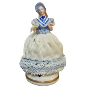 Figura de encaje de porcelana de Dresde vintage con ramo de flores y vestido azul y blanco.